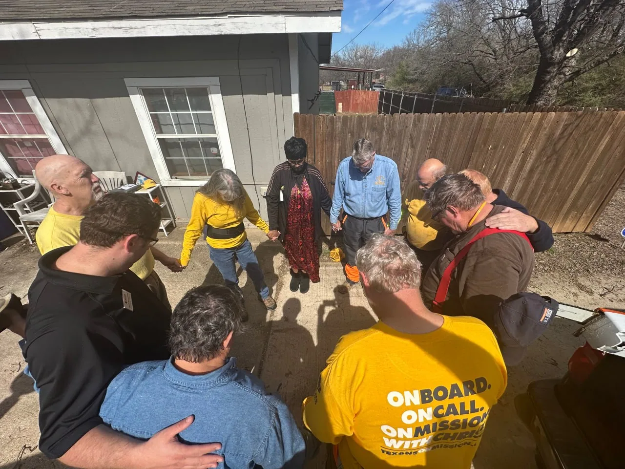 Volunteers and residents joining hands in prayer