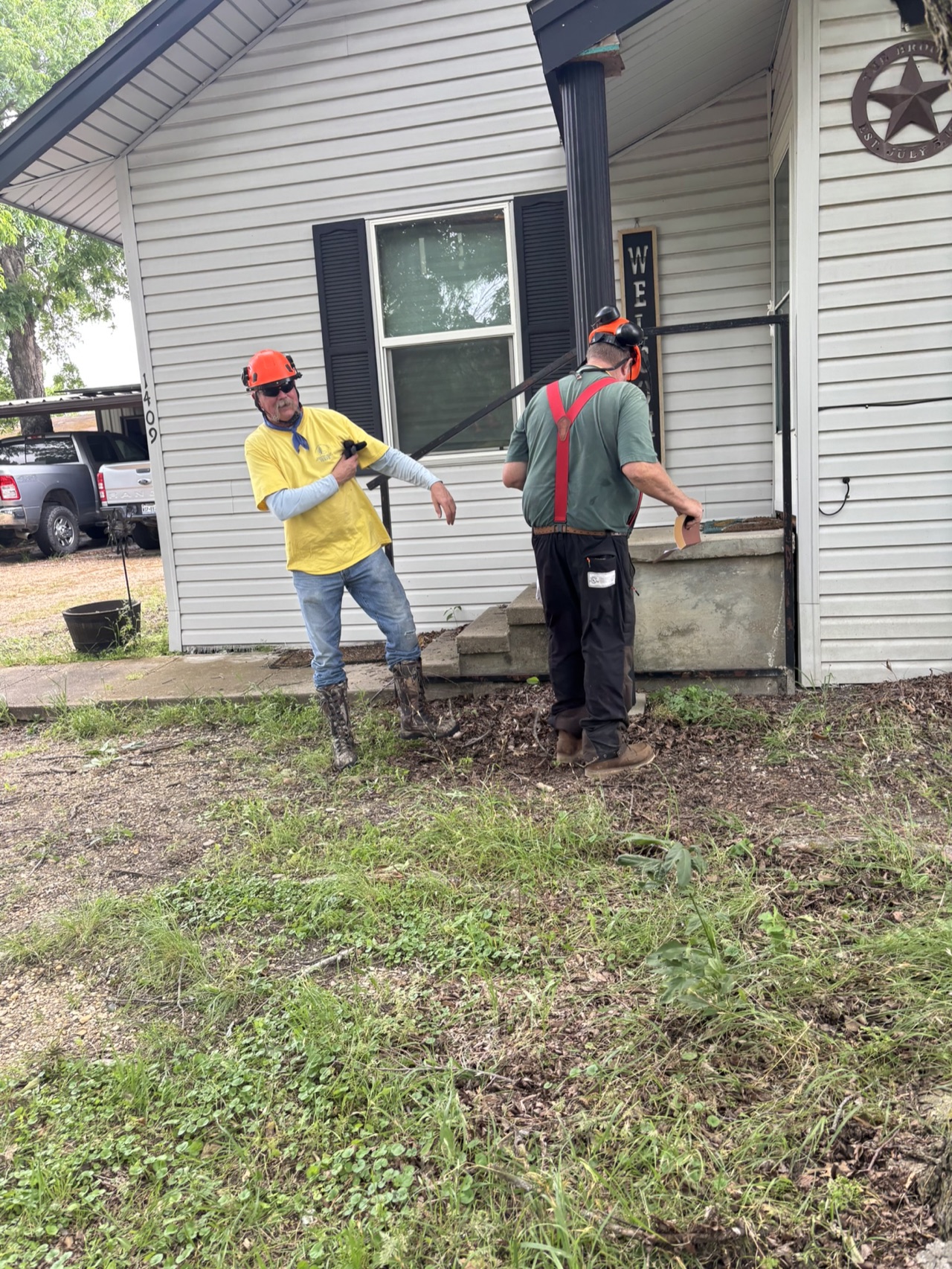 Chainsaw ministry volunteers working near a home during the Brooks community service project in Italy, Texas.