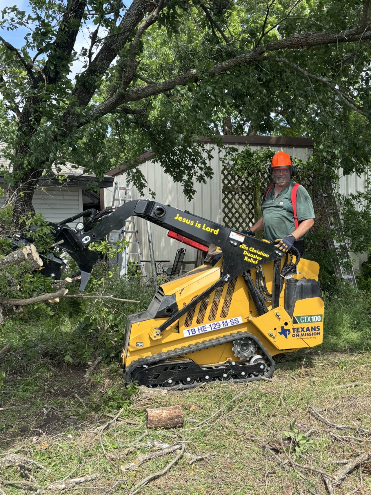 A Texans on Mission skid steer assisting with tree cleanup at the Brooks community service project.