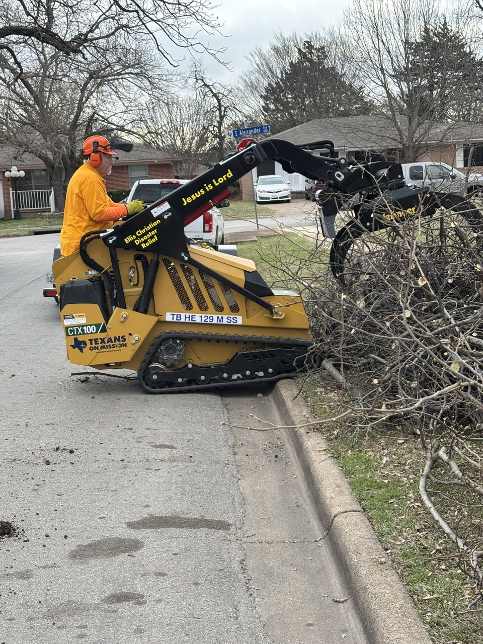 Volunteer cutting and stacking tree debris during the Duncanville community service project.