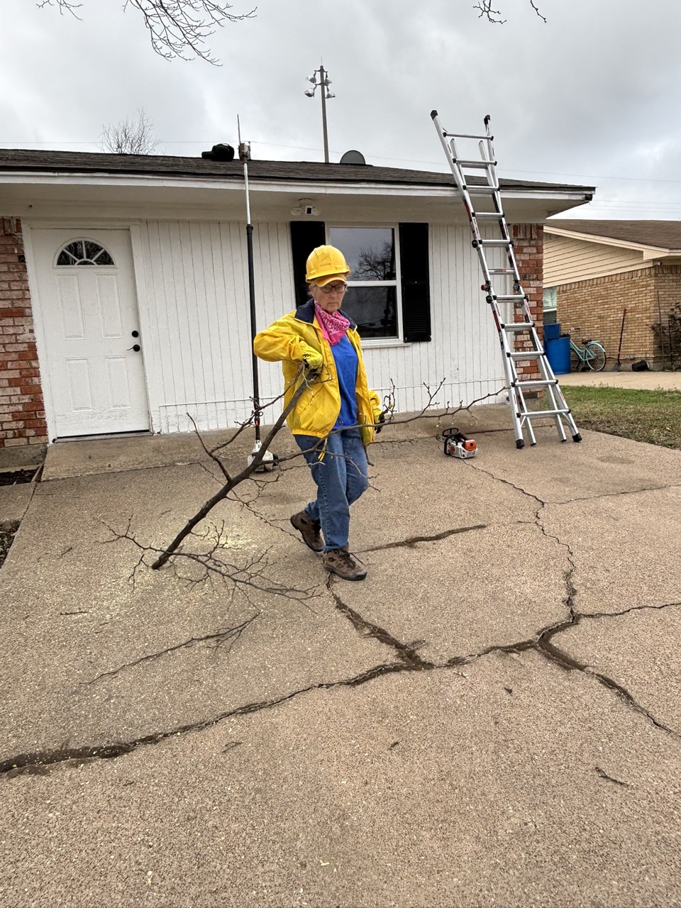Chainsaw ministry volunteers removing tree limbs from a yard during the Duncanville community service project.