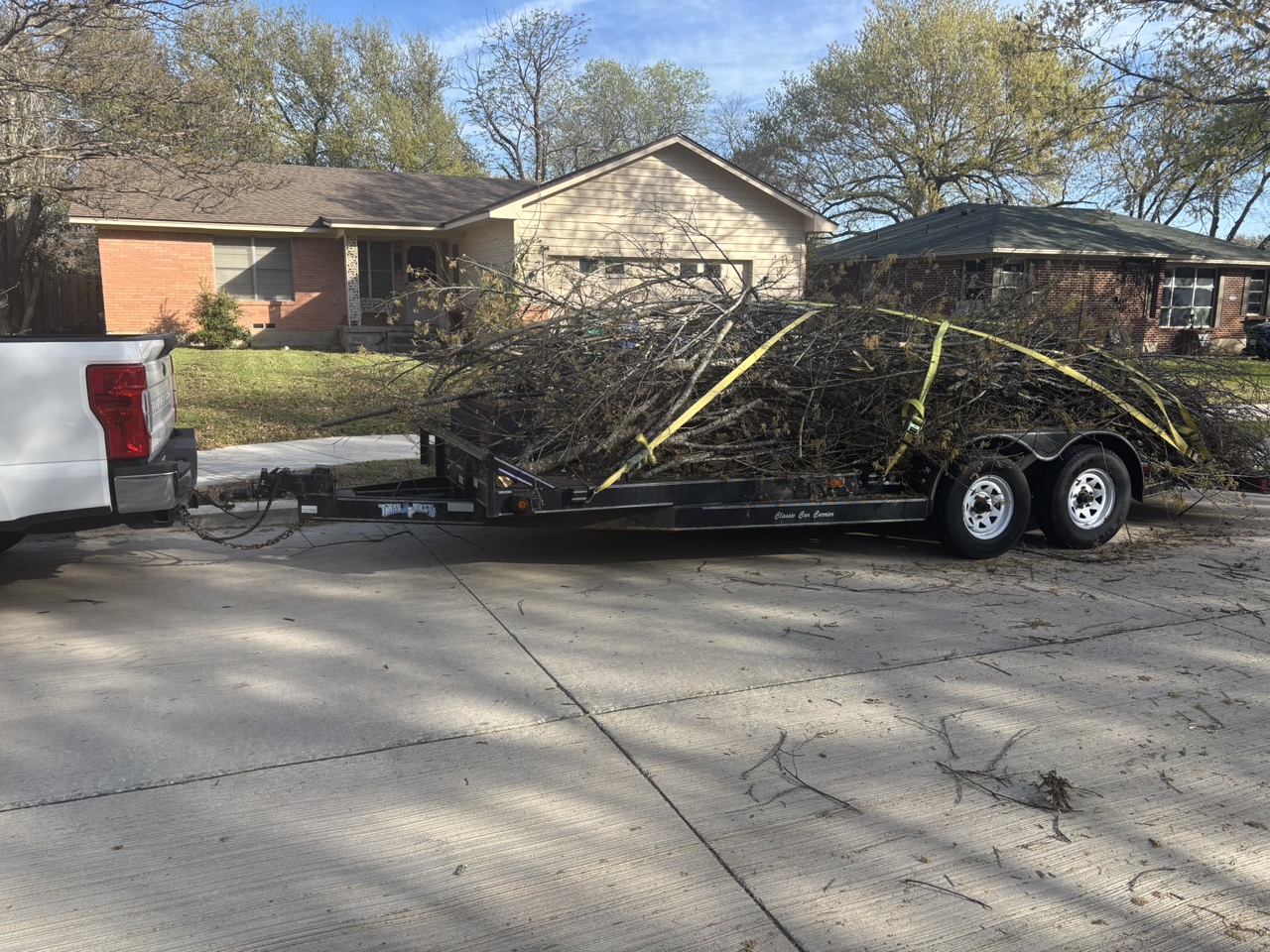 Cut branches loaded onto a trailer during the Waxahachie community service project.