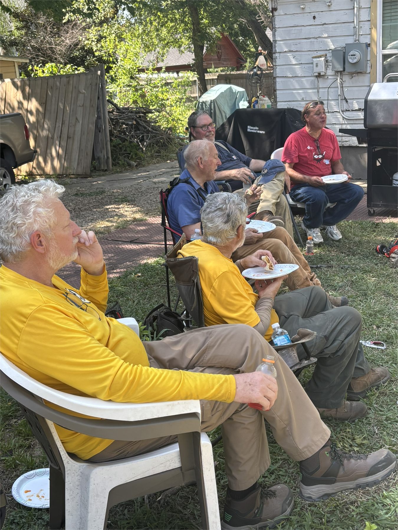 Community service volunteers share a meal break during the Waxahachie chainsaw project.