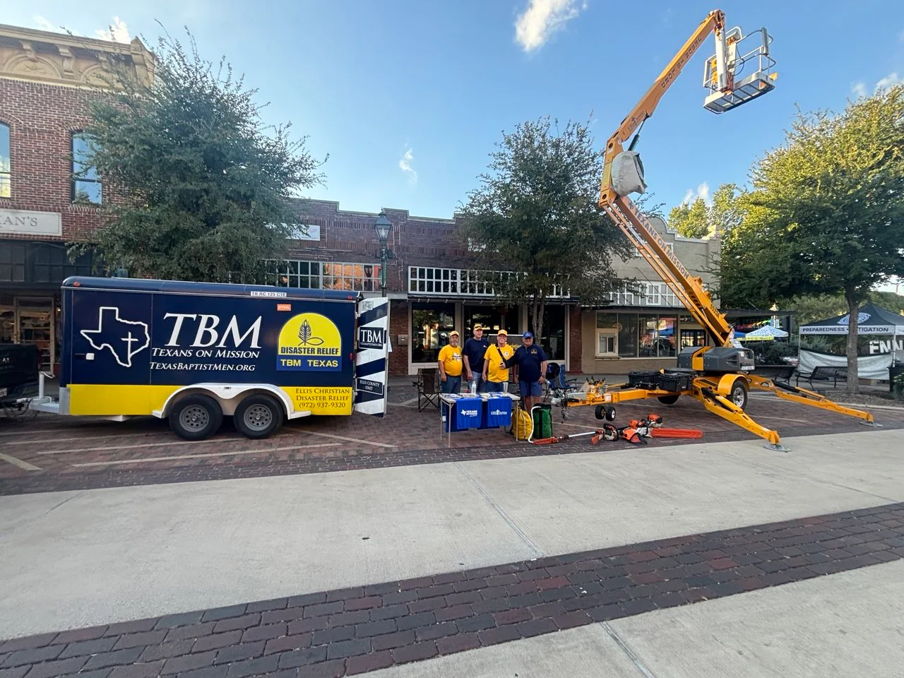 ECDR volunteers standing beside the Ellis County disaster relief trailer, ministry equipment, and raised bucket lift at the Preparedness Fair.