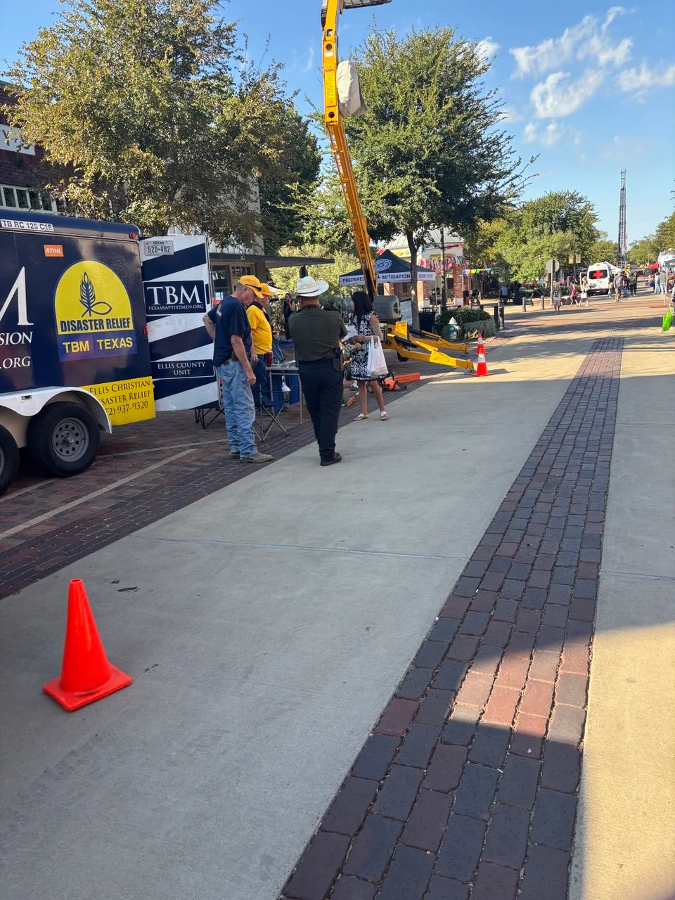 ECDR volunteers and fair visitors gathered near the disaster relief trailer and bucket lift in downtown Ennis.