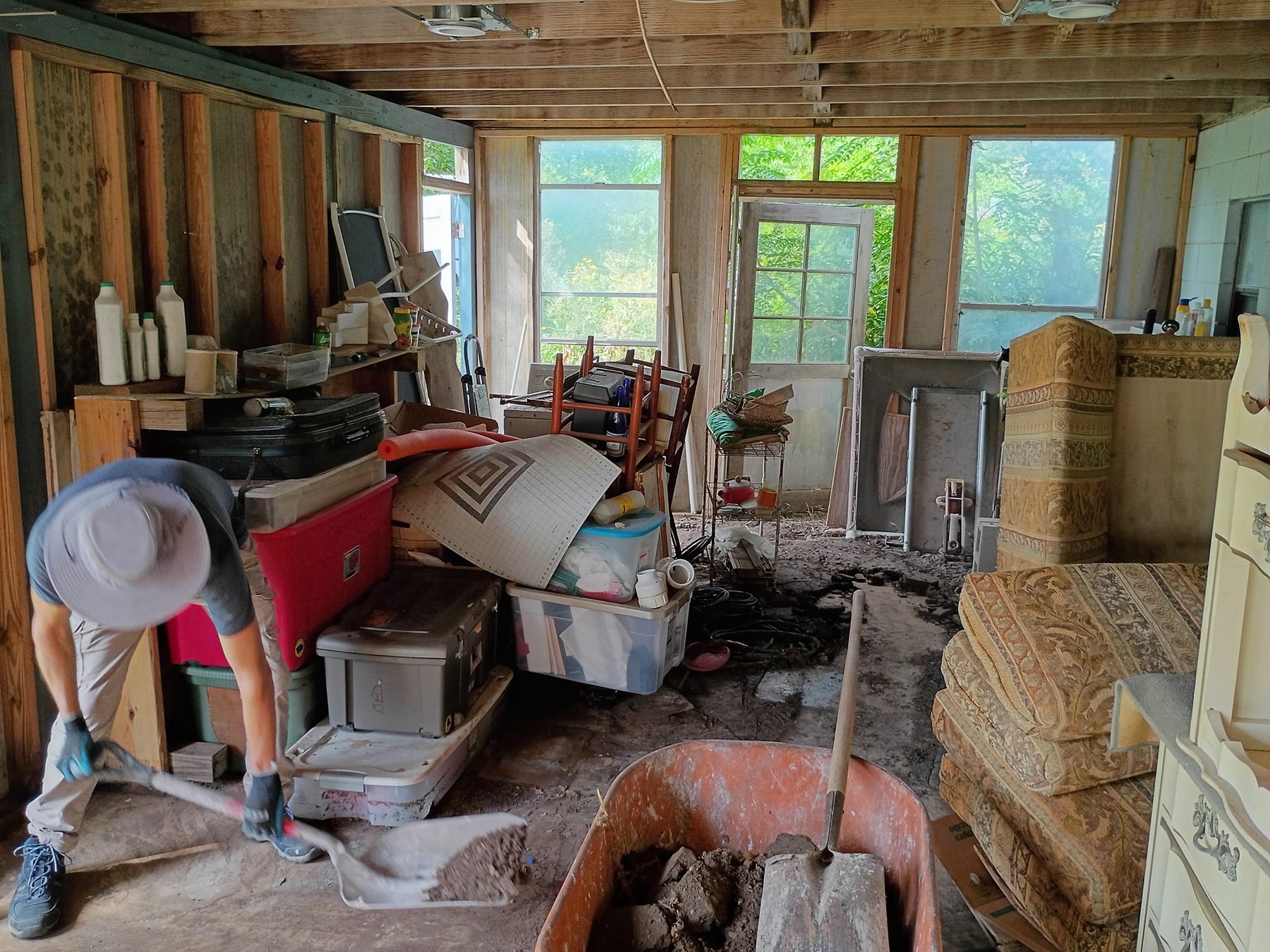 Volunteer removes dried mud and debris from a flood-damaged room in Kerrville.