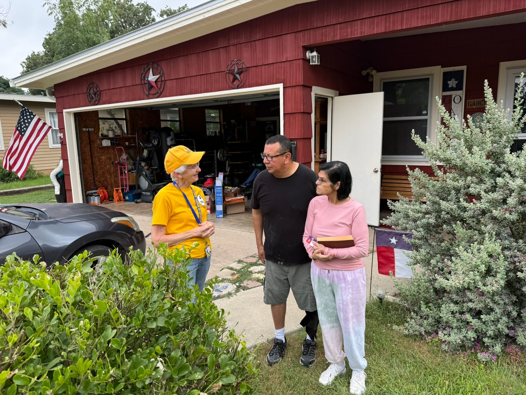Texans On Mission volunteer speaks with Kerrville residents outside their home.