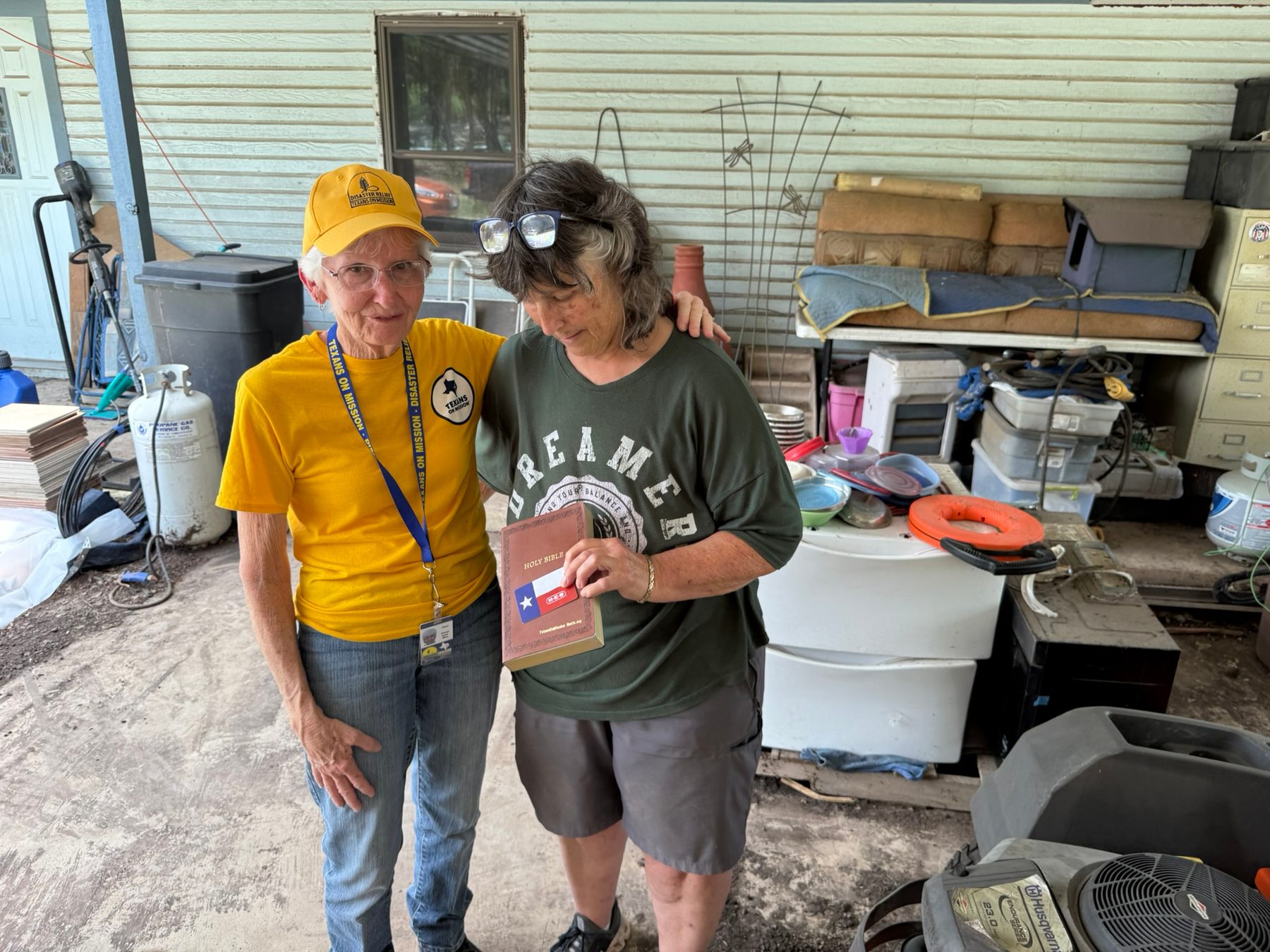 Texans On Mission volunteer offers a Bible and encouragement to a Kerrville resident.