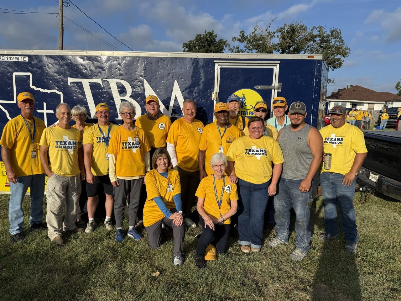Texans On Mission volunteers pose together beside a disaster relief trailer in Kerrville.