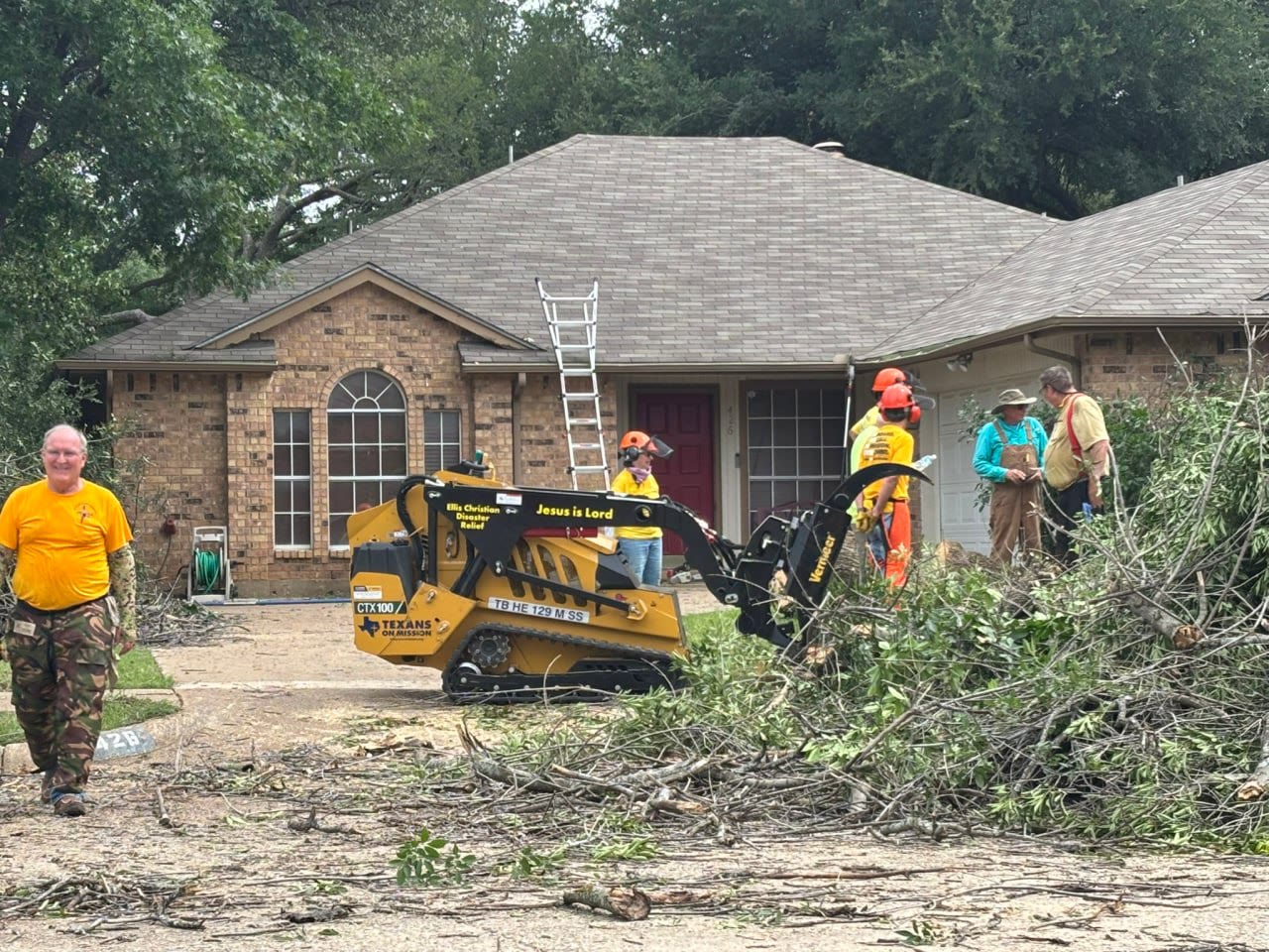 Texans on Mission volunteers clearing tree debris outside a Cedar Hill home during Mission Cedar Hill.