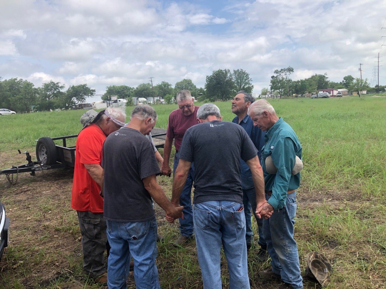 ECDR volunteers joining in prayer before serving in the field.