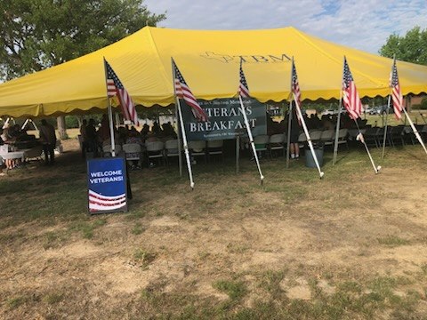 Large yellow ministry tent set up for a community event.
