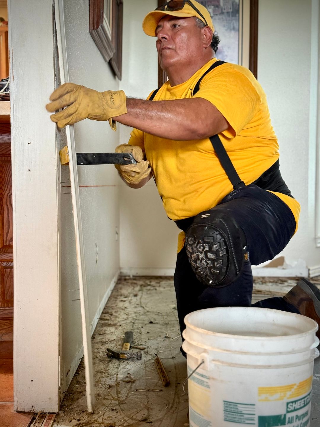 ECDR volunteer removing damaged material during flood recovery work inside a home.